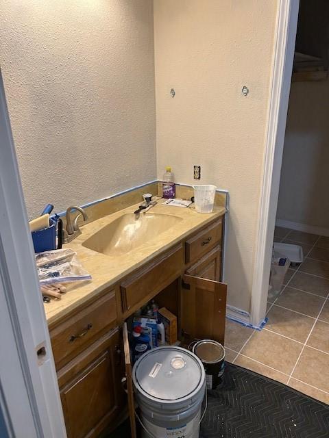 1103 NW 10th St, Bentonville, AR 72712 - bathroom with vanity, tile patterned floors, and a textured wall
