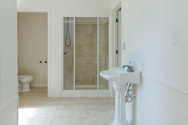 1103 NW 10th St, Bentonville, AR 72712 - bathroom with a stall shower, tile patterned flooring, and wainscoting