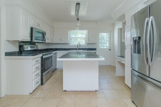 1103 NW 10th St, Bentonville, AR 72712 - kitchen featuring appliances with stainless steel finishes, white cabinetry, crown molding, light tile patterned floors, and a kitchen island