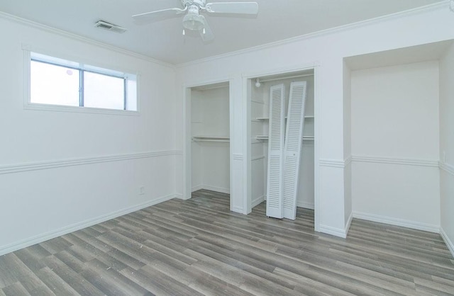 1103 NW 10th St, Bentonville, AR 72712 - unfurnished bedroom featuring two closets, wood finished floors, ornamental molding, and a ceiling fan