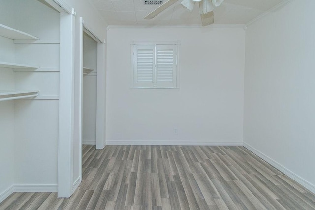 1103 NW 10th St, Bentonville, AR 72712 - unfurnished bedroom featuring wood finished floors, a closet, a ceiling fan, and ornamental molding