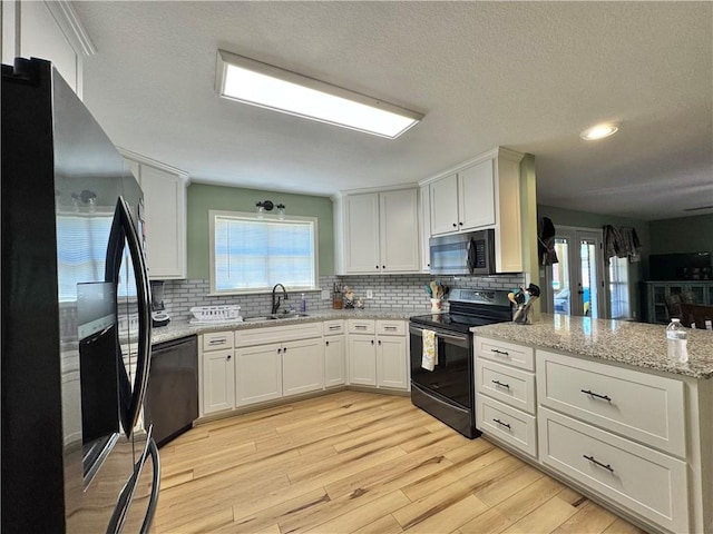 904 Deerfield Ct, Russellville, AR 72801 - kitchen with black appliances, a sink, a peninsula, white cabinets, and decorative backsplash