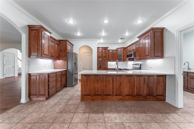 602 SW Brighton Dr, Bentonville, AR 72712 - kitchen featuring stainless steel appliances, arched walkways, a sink, crown molding, and a peninsula