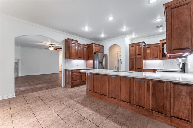602 SW Brighton Dr, Bentonville, AR 72712 - kitchen with arched walkways, stainless steel fridge, ceiling fan, a sink, and crown molding