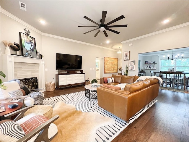 219 Kinross Dr, Bella Vista, AR 72715 - living room featuring dark wood-style floors, ceiling fan, a chandelier, crown molding, and a fireplace