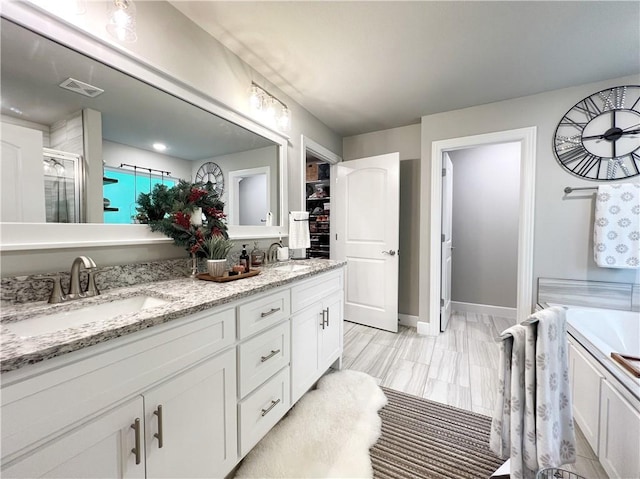 219 Kinross Dr, Bella Vista, AR 72715 - bathroom featuring double vanity, a shower with shower door, a bath, and baseboards