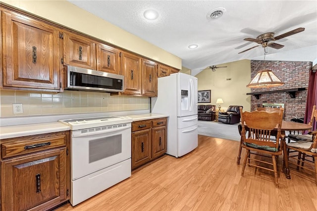 2001 W Magnolia St, Rogers, AR 72758 - kitchen featuring white appliances, a ceiling fan, brown cabinets, lofted ceiling, and open floor plan