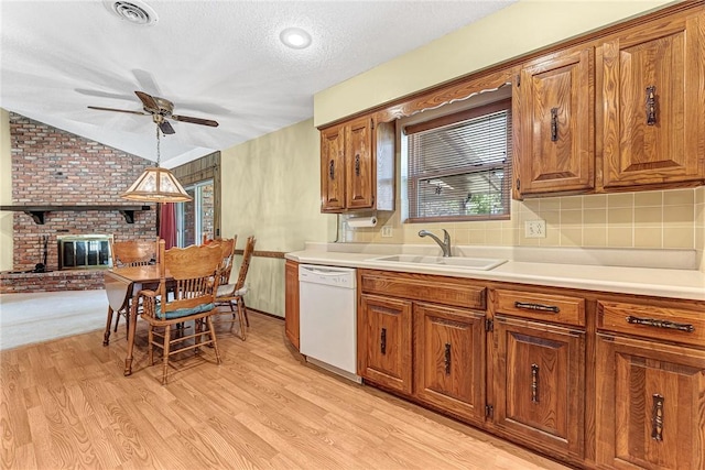 2001 W Magnolia St, Rogers, AR 72758 - kitchen featuring dishwasher, a sink, brown cabinetry, ceiling fan, and a textured ceiling