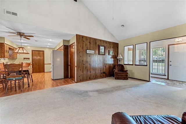 2001 W Magnolia St, Rogers, AR 72758 - living room with high vaulted ceiling, ceiling fan, light carpet, and wood walls