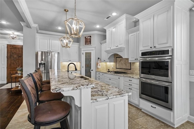 6401 S 47th St, Rogers, AR 72758 - kitchen with stainless steel appliances, a sink, a chandelier, white cabinetry, and recessed lighting