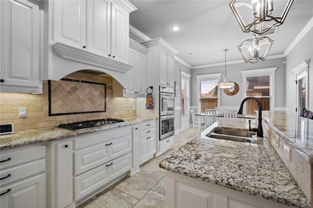 6401 S 47th St, Rogers, AR 72758 - kitchen with a sink, stainless steel appliances, white cabinetry, ornamental molding, and a chandelier