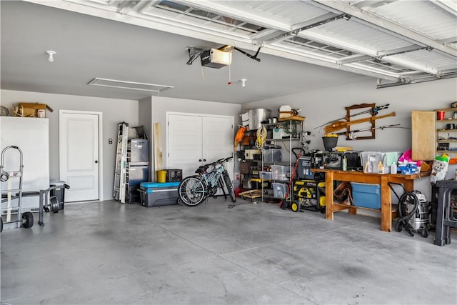 2300 Cameo Ln, Bentonville, AR 72712 - garage featuring freestanding refrigerator, a garage door opener, and a workshop area
