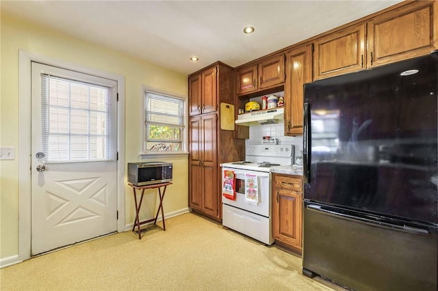 521 S 13th St, Rogers, AR 72758 - kitchen with freestanding refrigerator, electric stove, under cabinet range hood, light carpet, and brown cabinetry