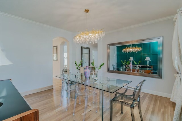4 W Colonial Dr, Rogers, AR 72758 - dining room featuring arched walkways, a chandelier, wood finished floors, ornamental molding, and baseboards