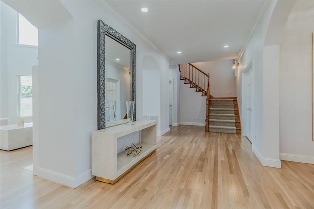 4 W Colonial Dr, Rogers, AR 72758 - hallway featuring crown molding, light wood-style floors, stairs, arched walkways, and baseboards