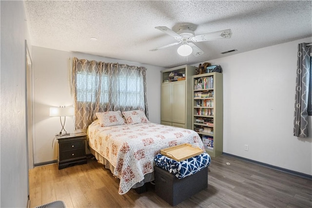 309 Sanders Ave, Springdale, AR 72764 - bedroom featuring wood finished floors, a textured ceiling, baseboards, and ceiling fan