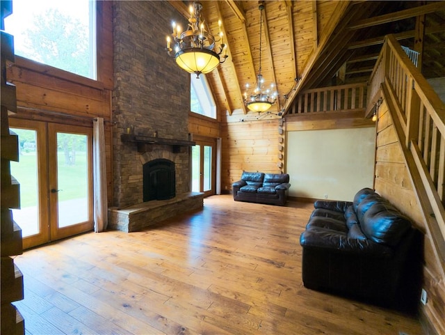 463 County Road 2281, Eureka Springs, AR 72631 - unfurnished living room featuring a chandelier, wood ceiling with exposed beams, high vaulted ceiling, wood-type flooring, and wood walls