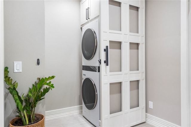 18097 Clear Water Rd, Fayetteville, AR 72704 - laundry room with estacked washer and dryer, cabinet space, and baseboards