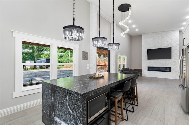18097 Clear Water Rd, Fayetteville, AR 72704 - kitchen featuring a chandelier, built in microwave, freestanding refrigerator, plenty of natural light, and a high ceiling