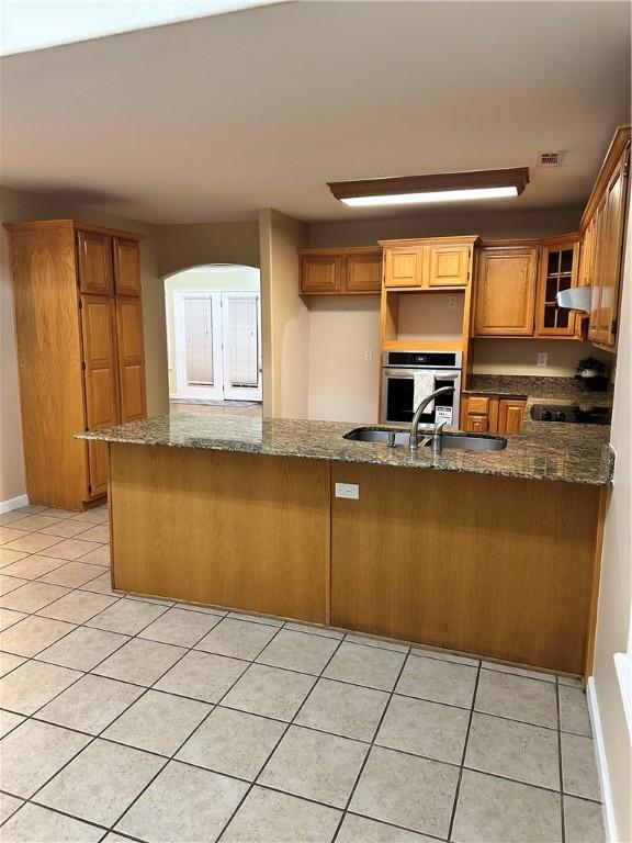 20944 Shady Grove Rd, Siloam Springs, AR 72761 - kitchen with stainless steel oven, under cabinet range hood, light tile patterned flooring, and dark stone counters