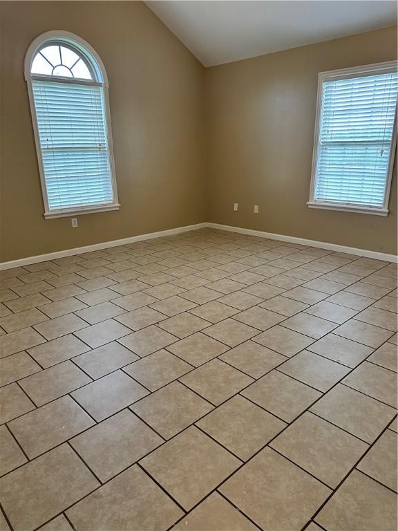 20944 Shady Grove Rd, Siloam Springs, AR 72761 - unfurnished room featuring plenty of natural light, lofted ceiling, baseboards, and light tile patterned floors