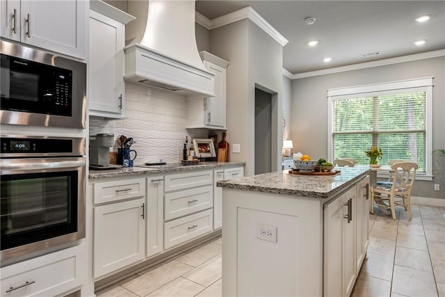 13 Ingleborough Dr, Bella Vista, AR 72715 - kitchen featuring custom exhaust hood, stainless steel appliances, crown molding, tasteful backsplash, and a kitchen island