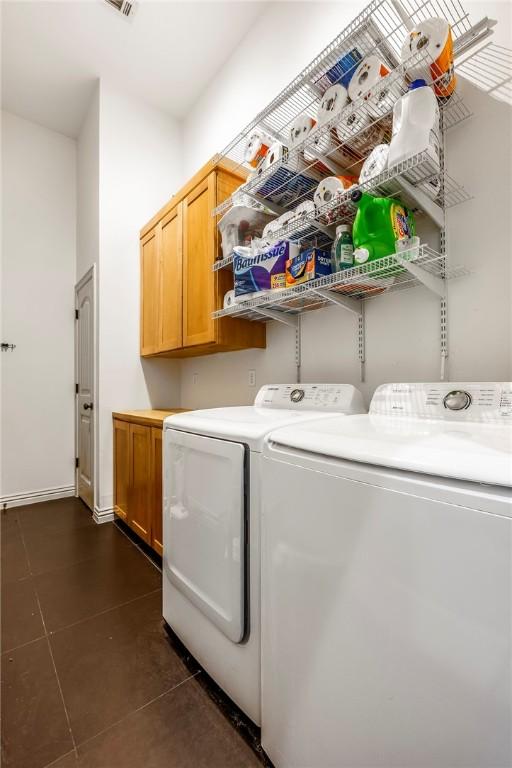 29 Kentallen Ln, Bella Vista, AR 72715 - laundry area featuring washing machine and dryer, cabinet space, and dark tile patterned floors