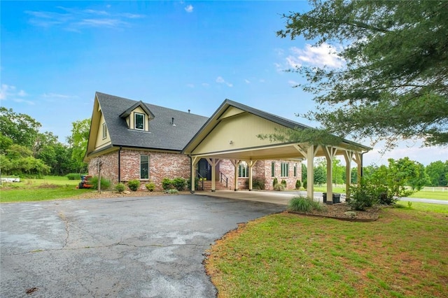 605 SW O St, Bentonville, AR 72712 - view of front of home with driveway, a front yard, brick siding, roof with shingles, and an attached carport
