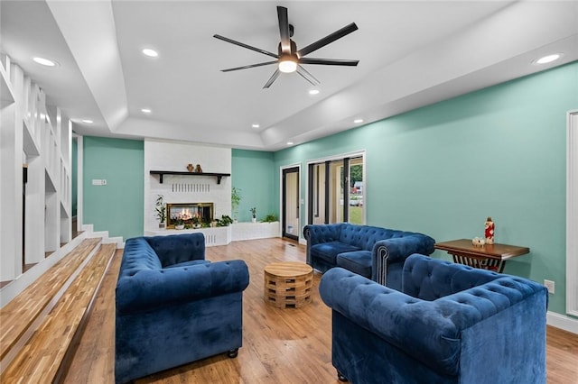 605 SW O St, Bentonville, AR 72712 - living room featuring light wood-style floors, a tray ceiling, recessed lighting, ceiling fan, and stairs