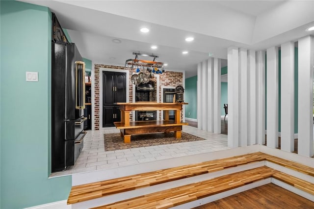 605 SW O St, Bentonville, AR 72712 - kitchen with high quality fridge, baseboards, recessed lighting, and wood finished floors