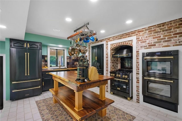 605 SW O St, Bentonville, AR 72712 - kitchen with black appliances, a sink, light tile patterned flooring, recessed lighting, and brick wall