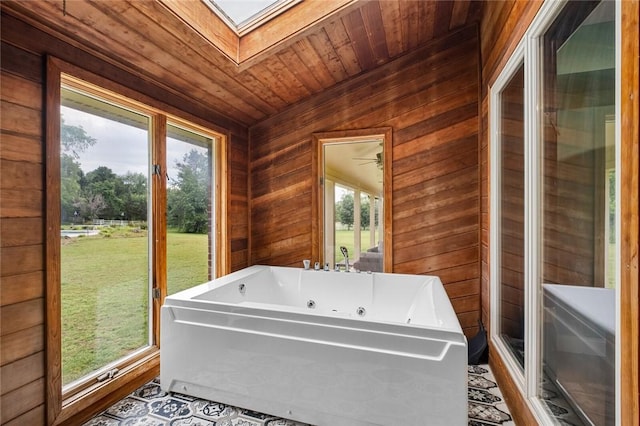 605 SW O St, Bentonville, AR 72712 - bathroom featuring a whirlpool tub, wooden walls, a skylight, and wooden ceiling