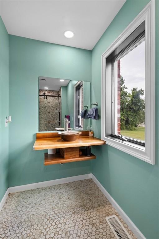 605 SW O St, Bentonville, AR 72712 - full bath with baseboards, tiled shower, and vanity
