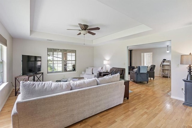 17171 Kincheloe Rd, Siloam Springs, AR 72761 - living area featuring a tray ceiling, ceiling fan, light wood finished floors, and baseboards