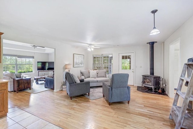17171 Kincheloe Rd, Siloam Springs, AR 72761 - living area with a ceiling fan, a wood stove, and light wood finished floors