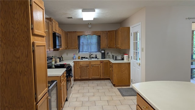 2560 Jayme Cir, Conway, AR 72032 - kitchen with black electric range oven, a sink, stainless steel microwave, brown cabinetry, and a textured ceiling