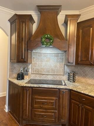 10211 Lydia Ln, Danville, AR 72833 - kitchen featuring black electric stovetop, premium range hood, baseboards, decorative backsplash, and light stone counters