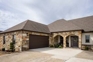 10211 Lydia Ln, Danville, AR 72833 - french country home with concrete driveway, stone siding, and an attached garage