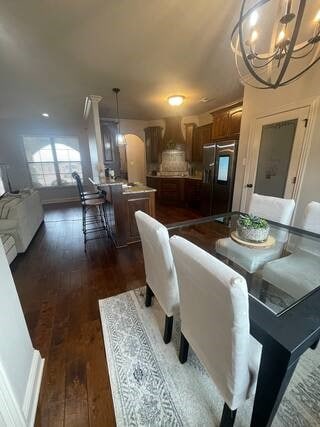 10211 Lydia Ln, Danville, AR 72833 - dining space with a chandelier, arched walkways, and dark wood finished floors