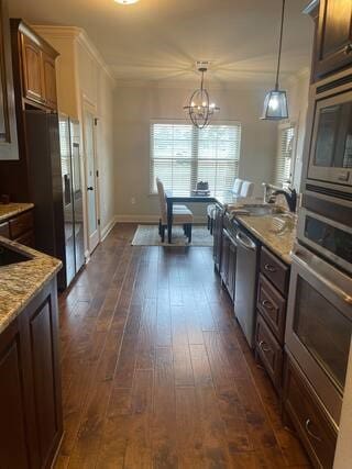 10211 Lydia Ln, Danville, AR 72833 - kitchen featuring appliances with stainless steel finishes, a chandelier, crown molding, dark wood-type flooring, and hanging light fixtures