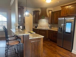 10211 Lydia Ln, Danville, AR 72833 - kitchen featuring stainless steel fridge, a peninsula, custom range hood, dark wood-style flooring, and a kitchen breakfast bar