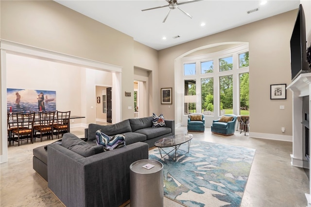3634 Sugarberry Ln, Springdale, AR 72764 - living area featuring a ceiling fan, a high ceiling, a fireplace, concrete floors, and baseboards
