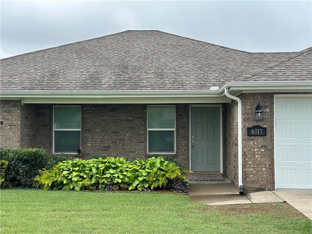 6013 Quinn St, Fayetteville, AR 72704 - property entrance featuring a shingled roof, brick siding, an attached garage, and a yard