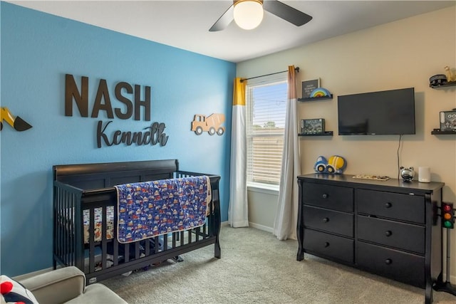 2409 S Silver St, Siloam Springs, AR 72761 - carpeted bedroom featuring a crib, baseboards, and ceiling fan