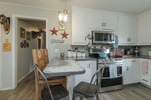 817 Madison 8610, Huntsville, AR 72740 - kitchen with stainless steel appliances, light wood-style floors, backsplash, white cabinets, and ornamental molding