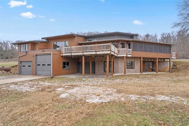 4933 Rocky Ridge Trl, Little Flock, AR 72756 - back of property featuring a sunroom, a garage, driveway, and a wooden deck