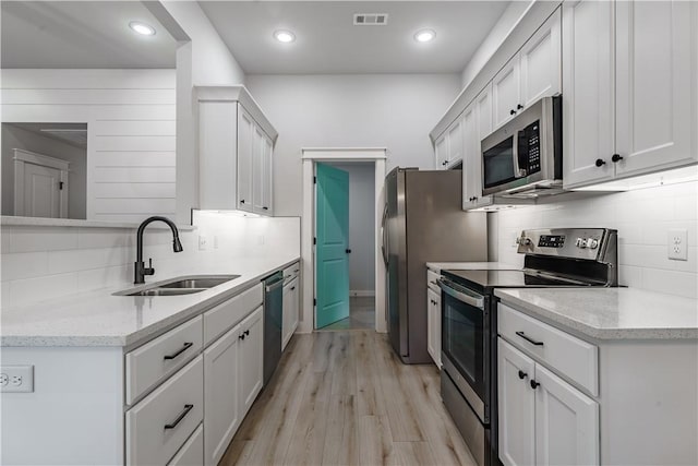 8 Grantham Dr, Bella Vista, AR 72714 - kitchen featuring stainless steel appliances, a sink, backsplash, light wood-style floors, and light stone counters