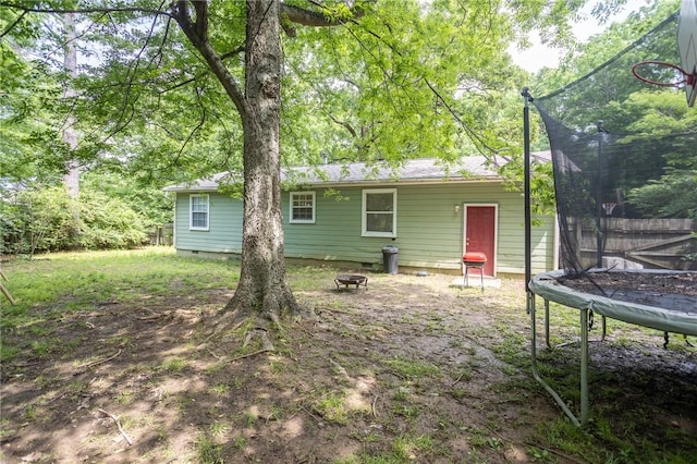 1627 W Hefley St, Fayetteville, AR 72703 - rear view of property featuring a trampoline, crawl space, and an outdoor fire pit