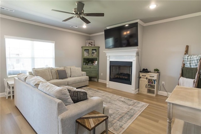 5803 SW Gentle Winds Ave, Bentonville, AR 72713 - living room with crown molding, a fireplace, light wood-style flooring, a ceiling fan, and baseboards