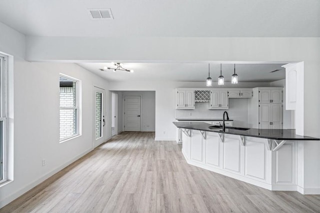 119 Elm St, Centerton, AR 72719 - kitchen featuring a sink, light wood-style flooring, baseboards, a peninsula, and a kitchen breakfast bar